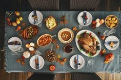 an overhead view of a thanksgiving dinner with turkey and sides on a blue table cloth