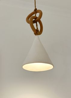 a white light hanging from a ceiling with a wooden ring on the top and bottom