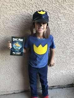 a young boy wearing a dog hat and blue shirt holding a dvd in front of his face