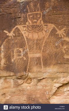 an ancient rock painting depicting a man with a beard and mustache on the side of a cliff