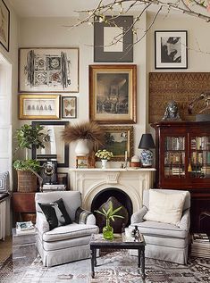 a living room filled with lots of furniture and pictures on the wall above it's fireplace