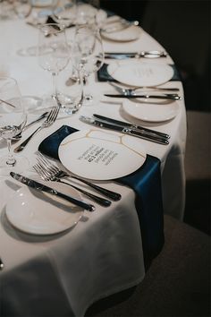 the table is set with white plates and silverware