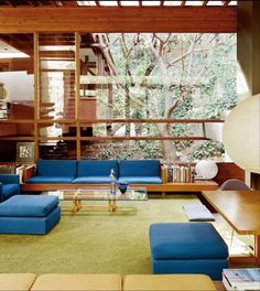 a living room with blue couches and green carpet