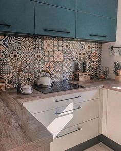 a kitchen with blue cabinets and tile backsplash