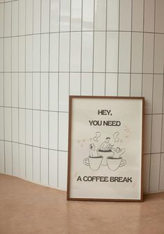 a coffee break poster sitting on top of a counter next to a wall with white tiles