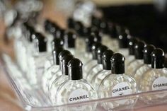 several bottles of chanel perfume sitting in a clear container on top of a table