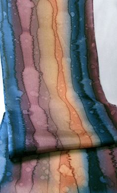 a tie dyed with different shades of blue, orange and pink on top of each other