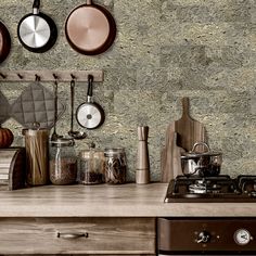 pots and pans are hanging on the wall next to an oven with cookware