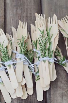 several wooden utensils tied with twine and sprig of rosemary on wood planks