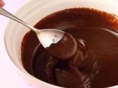 a spoon in a bowl filled with chocolate