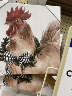 a chicken with a bow on it's neck is hanging from a sign in a store