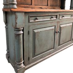 an old fashioned kitchen cabinet with wood top and metal pulls on the bottom, against a white background