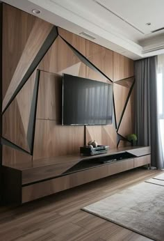 a modern living room with wood paneling and black accents on the wall, along with a large flat screen tv