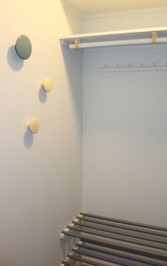 there is a coat rack in the corner of this room, and several circles on the wall