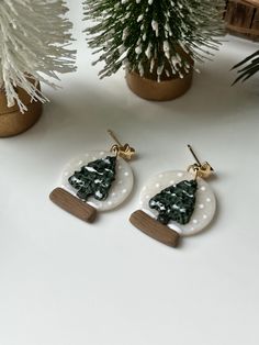 the earrings are decorated with green and white trees