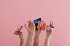 five hands holding up different types of candy in front of a pink background with the word love written on it