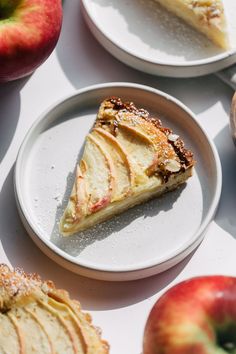 slices of apple pie on plates with apples in the background