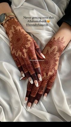 a woman's hands with henna tattoos on it