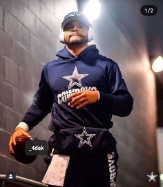 a man wearing a hoodie and holding a football