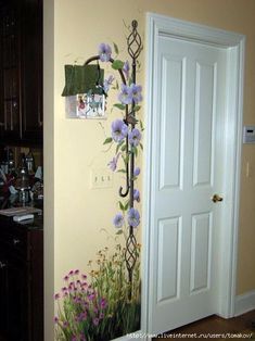 the door is open and there are flowers painted on the wall next to the doorway