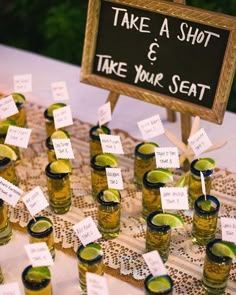 there are many shot glasses with limes in them sitting on the table next to each other