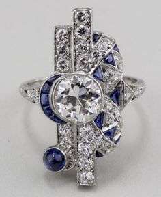 "𝐃𝐞𝐬𝐜𝐫𝐢𝐩𝐭𝐢𝐨𝐧 : *Antique Old European Cut Diamond Woman's Ring, Vintage Sapphire Diamond Ring, Edwardian Art Deco Ring, 925 Silver Wedding Ring, Fine Jewelry. ❖ 𝐃𝐢𝐚𝐦𝐨𝐧𝐝 𝐃𝐞𝐭𝐚𝐢𝐥𝐬 *Color : White, Blue *Clarity : VVS *Cut : Excellent *Center Stone Shape : Old European Cut *Center Stone Size : 7.00 MM *Center Stone Weight : 1.33 CT *Type : Cubic Zirconia (CZ) *We have all types of fancy & color Gemstone. For more queries please contact us immediately. ❖ 𝐑𝐢𝐧𝐠 𝐃𝐞𝐭𝐚𝐢𝐥𝐬 Luxury Sapphire Art Deco Jewelry, Art Deco Multi-stone Platinum Diamond Ring, White Sapphire Multi-stone Diamond Ring, White Diamond Gemstone Ring In Art Deco Style, Classic Multi-stone Sterling Silver Diamond Ring, Classic Multi-stone Diamond Ring In Sterling Silver, Classic Sterling Silver Multi-stone Diamond Ring, Exquisite Silver Sapphire Ring With Center Stone, Art Deco Multi-stone Diamond Ring