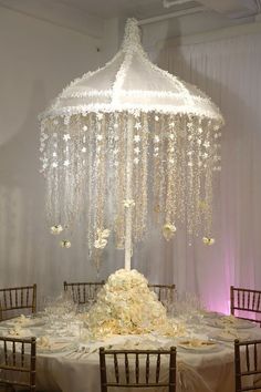 the table is set up with white flowers and chandelier hanging from the ceiling