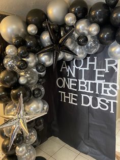 black and silver balloons with star decorations on the front, and another one bites the dust banner