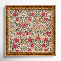 an ornately decorated wall hanging with flowers and leaves in gold frame on the wall