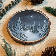 a wood slice with pine trees painted on it