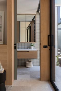 an open door leading to a bathroom with a sink and mirror on the wall next to it