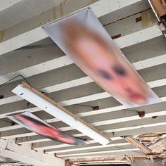 an unfinished room with some paintings hanging from the ceiling