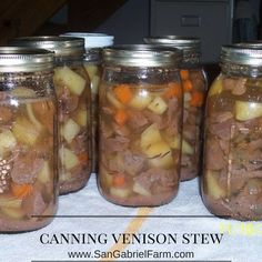 four jars filled with food sitting on top of a table