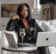 a woman sitting at a table with a glass of wine in front of her laptop