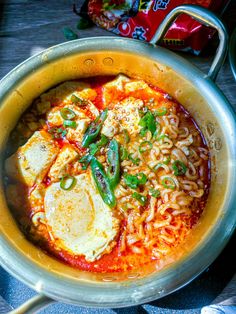 a pot filled with noodles and eggs on top of a table