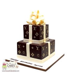 a three tiered cake decorated with chocolate and gold foiling, featuring the initials of louis vuitton