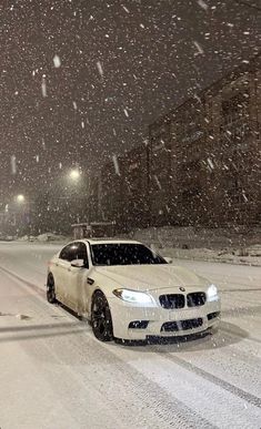 a white car driving down a snow covered street