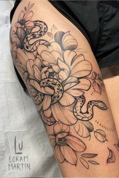 a woman's thigh with flowers and snake tattoo on her leg by loram martin