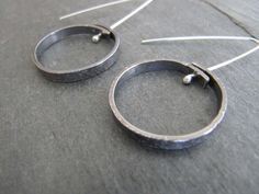 "Here are some simple affordable silver earrings that are easy to wear every day. These earrings are textured on the surface, formed into a circle, pierced, oxidized, buffed, and suspended from handmade polished sterling silver ear wires. The circle is about 1\" in diameter (25mm)" Silver And Gold Decorations, Kinetic Jewellery, Kinetic Jewelry, Disk Earrings, Silverware Crafts, Silver Circle Earrings, Gold Decorations, Creative Jewelry Photography, Handmade Silver Jewellery