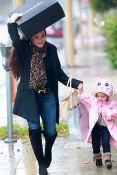 a woman and child walking down the street with bags on their heads, carrying shopping bags