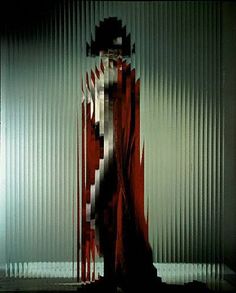 a woman standing in front of a metal wall with red and white stripes on it