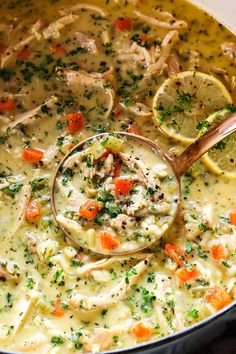 a ladle full of chicken noodle soup with lemons and parsley