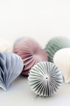 several different colored paper fans on a white surface