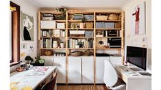 a home office with shelving, desk and computer