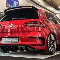 the rear end of a red vw golf gtr on display at an auto show