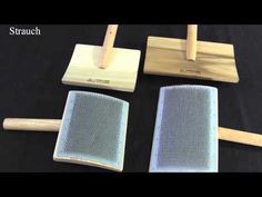 four pieces of wood and mesh on top of a black cloth covered table with two wooden spatulas