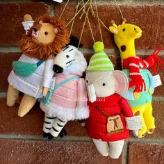 three stuffed animals hanging on a brick wall