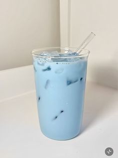 a blue drink with ice and straw in it