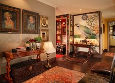 a living room filled with furniture and pictures on the wall above it's doorway