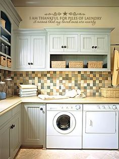 a washer and dryer sitting in a kitchen next to cabinets with baskets on them